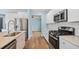 Modern kitchen with stainless steel appliances, white cabinetry and quartz countertops, perfect for cooking at 107 Cotton Blossom Way, Summerville, SC 29485