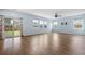 Open-concept living room with hardwood floors, three windows and a glass sliding door that leads to the yard at 107 Cotton Blossom Way, Summerville, SC 29485