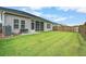 Manicured backyard with lush green grass, tall wood privacy fence, and screened in porch at 112 Mayfield Dr, Goose Creek, SC 29445