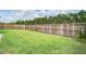 Large, fenced backyard with lush green grass and mature trees providing privacy at 112 Mayfield Dr, Goose Creek, SC 29445