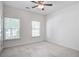 Neutral carpeted bedroom featuring two windows, a ceiling fan, and a white door at 112 Mayfield Dr, Goose Creek, SC 29445