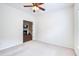 Bright bedroom with neutral carpet, ceiling fan, and doorway to a room with a fireplace at 112 Mayfield Dr, Goose Creek, SC 29445