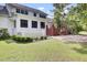 A beautifully maintained white home back exterior with brick trim and a lush green lawn, perfect for families and entertaining at 115 Old Postern Rd, Summerville, SC 29483