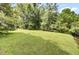 Expansive green backyard lawn surrounded by mature trees and landscaping at 115 Old Postern Rd, Summerville, SC 29483