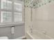 This bathroom features a tub and shower with white tile, and shuttered windows at 115 Old Postern Rd, Summerville, SC 29483