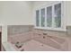 Relax in this soaking tub with tile surround and shuttered window at 115 Old Postern Rd, Summerville, SC 29483