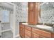 This bathroom features wood cabinets, double sinks, and floral wallpaper at 115 Old Postern Rd, Summerville, SC 29483