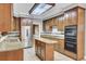 Classic kitchen showcasing wooden cabinets, granite countertops, stainless steel appliances, and tiled floors at 115 Old Postern Rd, Summerville, SC 29483