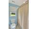 Cozy bathroom features a toilet near a window overlooking green outdoors and a shower with a simple curtain at 1199 Parkway Drive, Mount Pleasant, SC 29464