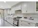 Modern kitchen boasts bright white cabinets, stainless appliances, and marble countertops at 1199 Parkway Drive, Mount Pleasant, SC 29464