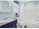 Well-lit bathroom featuring a sink with granite countertop, and a bathtub with shower and toiletry shelf at 123 Jungle Rd, Edisto Island, SC 29438
