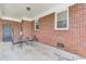 Covered back porch featuring a brick exterior and metal table and chairs at 1237 Fort Dr, Hanahan, SC 29410