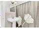 Bright bathroom showcasing a pedestal sink, decorative shower curtain, and classic tiled walls at 1237 Fort Dr, Hanahan, SC 29410
