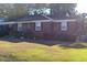 Cozy brick home featuring a well-maintained lawn, trimmed shrubs, and a welcoming front entrance at 1237 Fort Dr, Hanahan, SC 29410