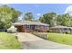Inviting brick home featuring a boat parked on the driveway, complemented by lush trees and manicured lawn at 1237 Fort Dr, Hanahan, SC 29410
