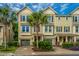 Inviting street view of townhouses with palm trees, mature landscaping, and attached garages at 1253 Dingle Rd, Mount Pleasant, SC 29466