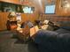 Living room featuring wood paneling and a plaid sofa with cardboard boxes at 126 Rattlensnake Trl, Walterboro, SC 29488