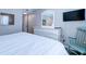 Cozy bedroom features light walls, a dresser with a mirror, and a comfortable bed at 1400 Ocean Blvd # 106B, Isle of Palms, SC 29451