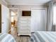 Bedroom with white dresser and TV, and hardwood flooring at 1400 Ocean Blvd # 106B, Isle of Palms, SC 29451
