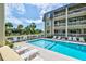 Exterior shot of the community pool with lounge chairs and palm trees at 1400 Ocean Blvd # 106B, Isle of Palms, SC 29451