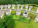 Aerial shot of homes with lush green lawns and solar panels, nestled among trees and neighborhood streets at 141 Sweet Cherry Ln, Summerville, SC 29486