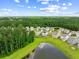 Aerial view of a residential area featuring houses, trees, and a serene pond surrounded by lush greenery at 141 Sweet Cherry Ln, Summerville, SC 29486