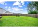 Large backyard with lush green grass, surrounded by a wooden privacy fence and neighboring homes at 141 Sweet Cherry Ln, Summerville, SC 29486