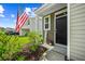 Inviting front entrance with a black door, a 'welcome' sign, and lush landscaping featuring a flowering bush at 141 Sweet Cherry Ln, Summerville, SC 29486