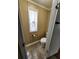 Compact half-bathroom featuring a toilet, patterned flooring, and a window with stylish valance, maximizing space efficiently at 149 Old Red Hill Rd, Ridgeville, SC 29472