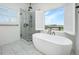 This bathroom features a stand alone tub, glass shower, and a view of the marsh at 1520 Regimental Ln, Johns Island, SC 29455