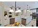 Bright, open kitchen with white cabinets, an island, stainless steel appliances, and an open view to the living room at 1664 William Hapton Way, Mount Pleasant, SC 29466