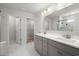 Bright bathroom with double sink vanity, large mirror, and tiled floor with walk-in closet access at 1950 Parish House Cir, Johns Island, SC 29455
