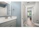 Bright bathroom featuring a gray vanity with a white countertop, a mirror, and floral shower curtain at 1950 Parish House Cir, Johns Island, SC 29455