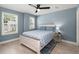 Serene bedroom with blue walls, light wood floors, two windows, and a decorative bedside table at 1950 Parish House Cir, Johns Island, SC 29455