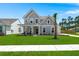 Inviting two-story home featuring a covered front porch and a lush green lawn at 1950 Parish House Cir, Johns Island, SC 29455
