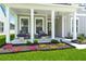 Charming front porch with rocking chairs, decorative plants, and ambient lighting at 1950 Parish House Cir, Johns Island, SC 29455
