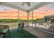 Cozy screened patio with comfortable seating, string lights, and sunset views at 199 Decatur Dr, Summerville, SC 29486