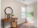 Bright bedroom featuring wood floors, light walls, two windows, and a stylish console table with decorative mirror at 202 Chandler Dr, Ladson, SC 29456