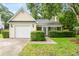 Quaint house with a one-car garage, lovely yellow siding, and greenery enhancing the curb appeal at 202 Chandler Dr, Ladson, SC 29456