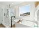 Bright bathroom with a free-standing tub, a large window and glass shower with black trim at 2050 Mcguire Ln # 13, Hollywood, SC 29449