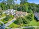 Well-maintained home with a lush green lawn, mature trees, and a long driveway leading to a garage at 206 President Cir, Summerville, SC 29483
