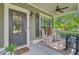 Inviting front porch featuring comfortable seating, decorative shutters, and stylish outdoor lighting at 206 President Cir, Summerville, SC 29483