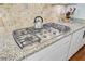 Close-up of a gas range with granite countertops and stylish backsplash in a modern kitchen at 206 President Cir, Summerville, SC 29483