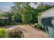 Spacious backyard featuring a brick patio, mature trees, lush landscaping, and a privacy fence at 2234 Kemmerlin St, Johns Island, SC 29455