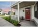 Inviting front porch with a red door, decorative wreath, exterior lantern, and manicured landscaping at 2234 Kemmerlin St, Johns Island, SC 29455