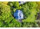 An aerial view of a home with a blue roof surrounded by lush green trees and marshland at 2287 Shoreline Dr, Johns Island, SC 29455