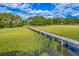 A beautiful wooden dock stretches across the backyard marsh, providing access to waterfront activities and scenic views at 2287 Shoreline Dr, Johns Island, SC 29455