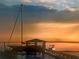 A scenic waterfront dock featuring a sailboat and boat under a picturesque sunset at 2287 Shoreline Dr, Johns Island, SC 29455