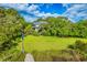 Spacious front yard with mature trees, a lush lawn, and waterfront views from the dock at 2287 Shoreline Dr, Johns Island, SC 29455