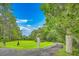 Driveway leading into the property featuring lush greenery and mature trees, offering privacy at 2287 Shoreline Dr, Johns Island, SC 29455